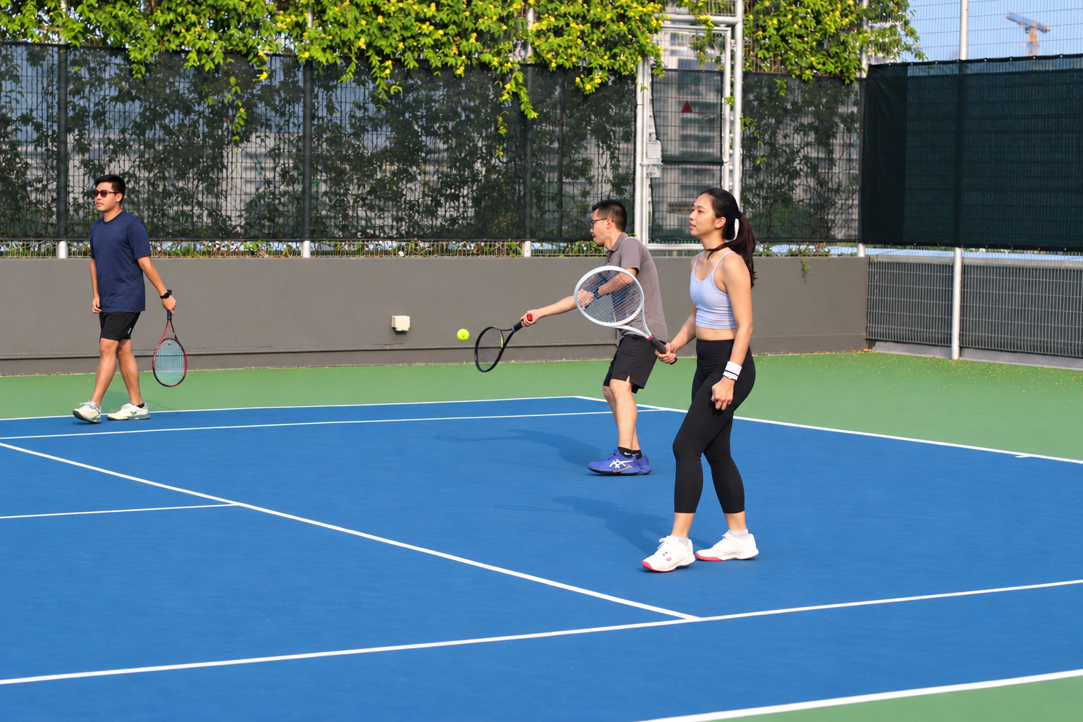 Three tennis players with rackets on a sunny blue tennis court